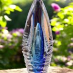 Design urn made of glass with transparent tone-on-tone blue ash chamber and 3D lines of molten glass over the urn – suitable for cremation ashes.