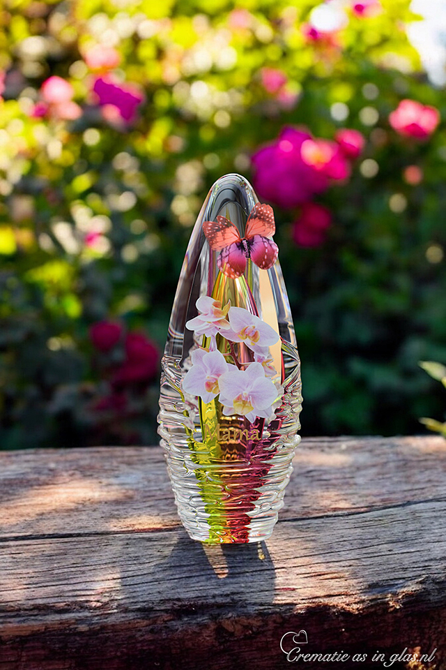 Glass design urn with yellow-pink ash chamber and image of orchids with space for a short name – suitable for cremation ashes.