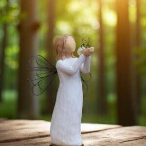 Willow Tree figurine Angel of Freedom releasing a butterfly with a glass mini urn attached near the butterfly.