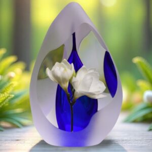 Design urn made of glass with transparent blue ash chamber and image of white freesias – suitable for cremation ashes.