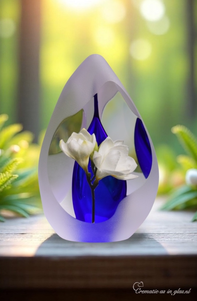 Design urn made of glass with transparent blue ash chamber and image of white freesias – suitable for cremation ashes.