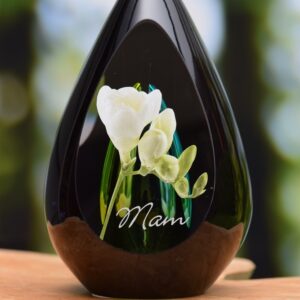 Design urn made of glass with transparent green-yellow ash chamber and image of white freesias – suitable for cremation ashes.