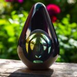 Design urn made of glass with green-yellow ash chamber and an air bubble pattern above the ash chamber – suitable for cremation ashes.