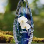 Design urn made of glass with transparent green-yellow ash chamber and image of white freesias – suitable for cremation ashes.