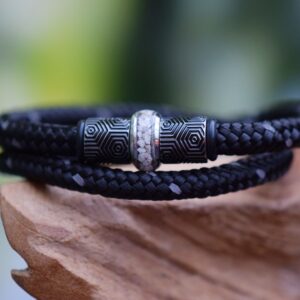 Black men’s bracelet with ashes in central stainless-steel bead between design beads.