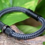 Anthracite men’s sailrope bracelet with ashes in central stainless-steel bead between black metallic beads.