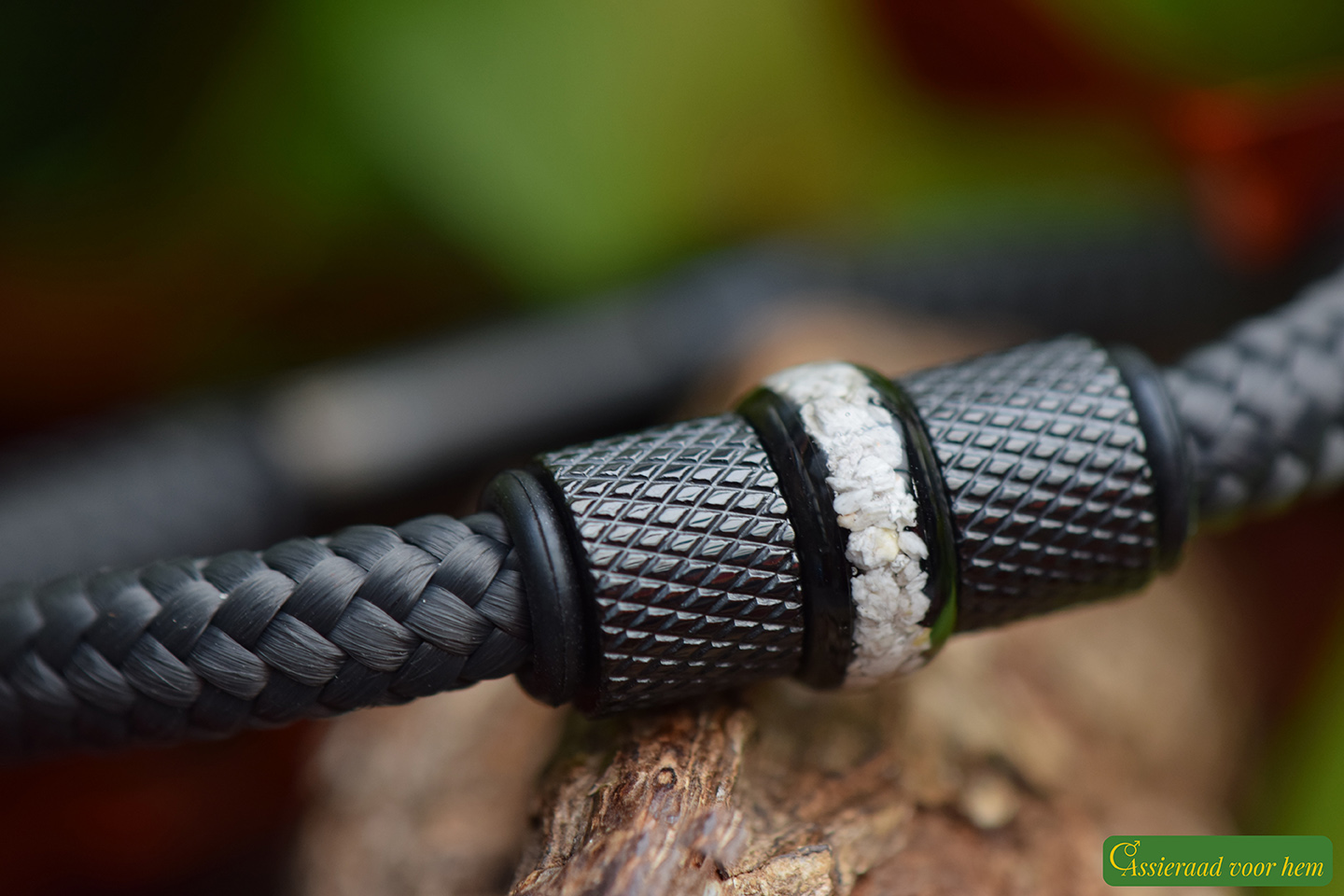 Close-up of ashes bead between two black metallic stainless-steel beads on anthracite rope band.