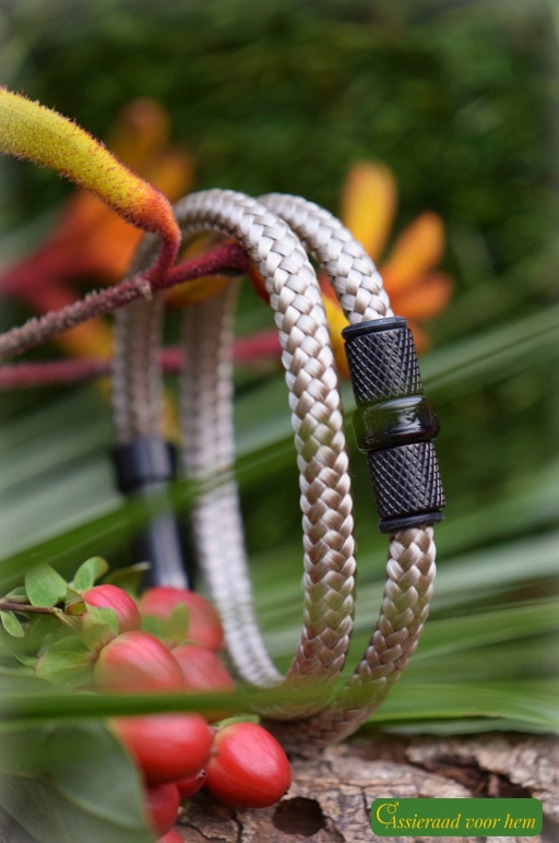 Vertical photo of khaki men’s memorial bracelet with ashes bead between black metallic design beads.