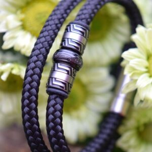 Men’s memorial bracelet in black sailrope with cremation ashes in stainless-steel bead and silver clasp.