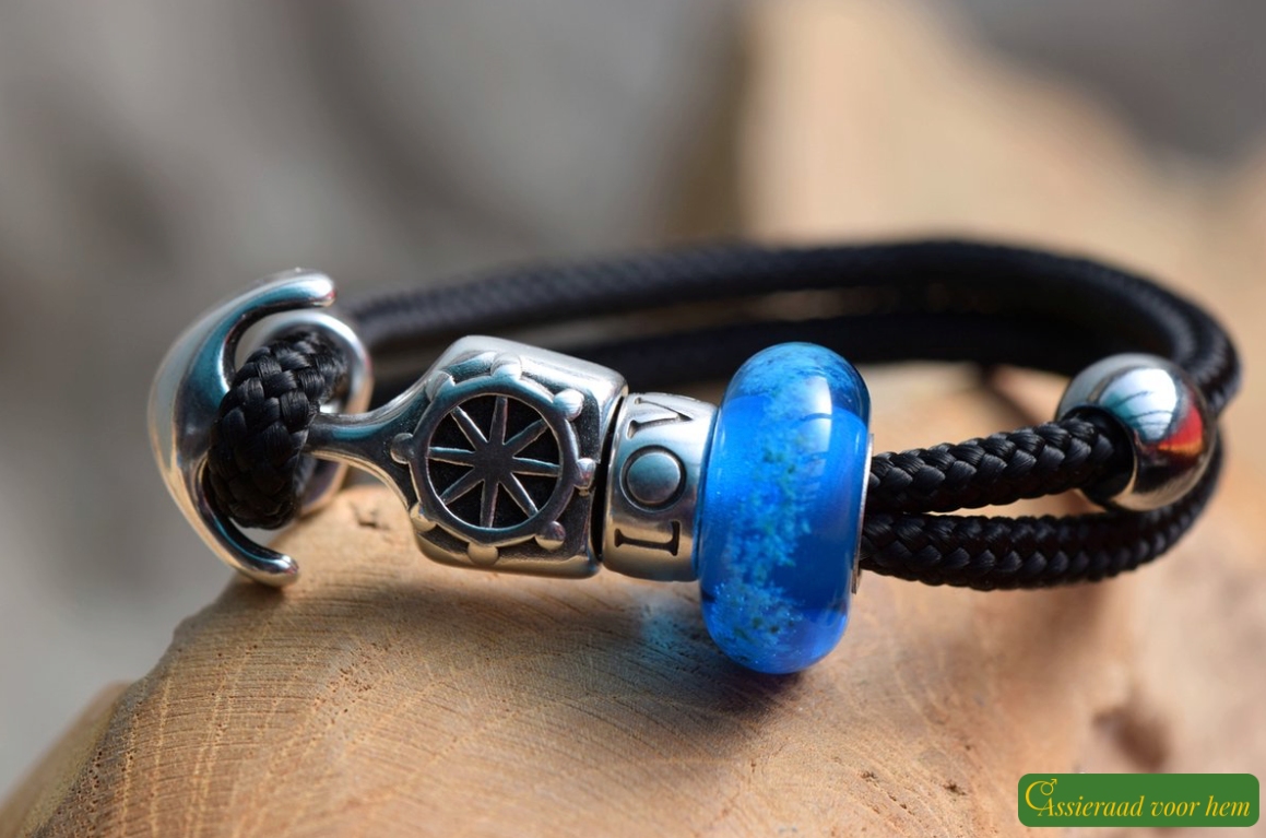 Men’s memorial bracelet in black sailrope with transparent blue glass bead containing cremation ashes.