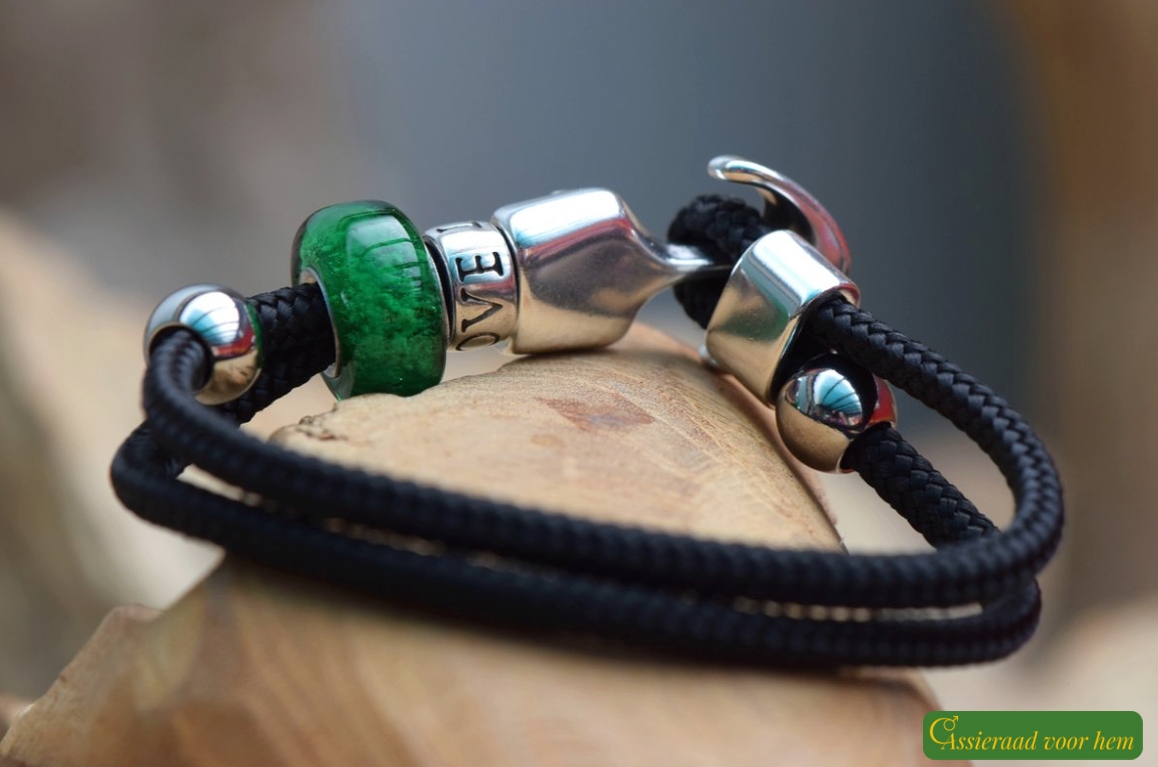 Front view of black men’s memorial bracelet with transparent green cremation ashes glass bead.
