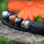 Men’s memorial bracelet in black sailrope with transparent brown glass bead containing cremation ashes.