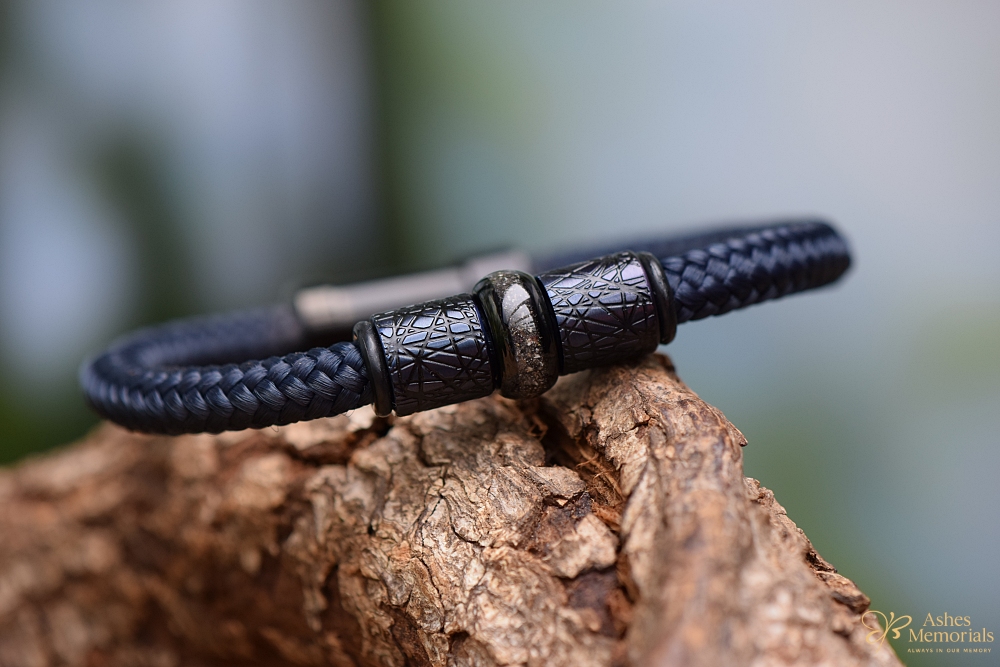 Dark blue men’s bracelet with ashes in central black stainless-steel bead.