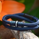 Men’s memorial bracelet in blue sailrope with cremation ashes in stainless-steel bead and black clasp.