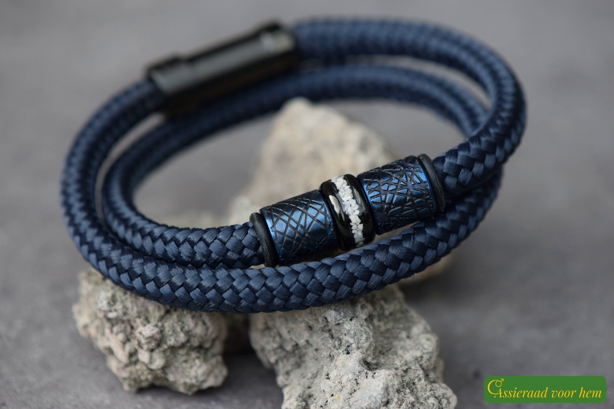 Memorial bracelet with cremation ashes bead between rubber stoppers and metallic design beads.