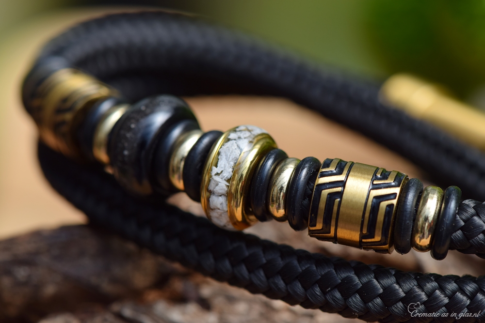 Detail view of double sailrope bracelet showing ashes set in gold and black stainless-steel beads.