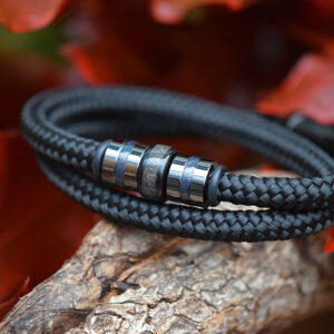 Black sailrope men’s bracelet with ashes in central stainless-steel bead between gun black beads.
