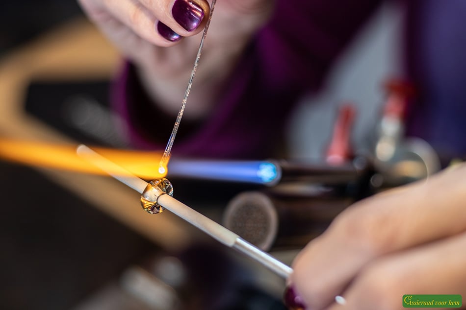 Amber cremation ashes glass bead being handmade during the glassblowing process in the studio.