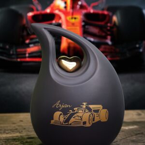 Black ceramic cremation urn with racing car design in teardrop shape with space for a name.