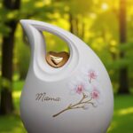Cremation ashes memorial urn white ceramic teardrop with orchid design and gold heart detail for human ashes.