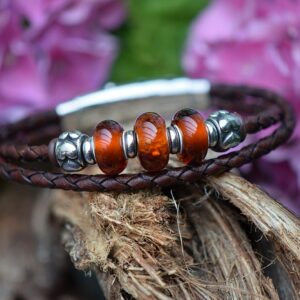 Dark brown braided leather memorial bracelet for men with three brown glass beads, visible cremation ashes and vintage stainless steel details.